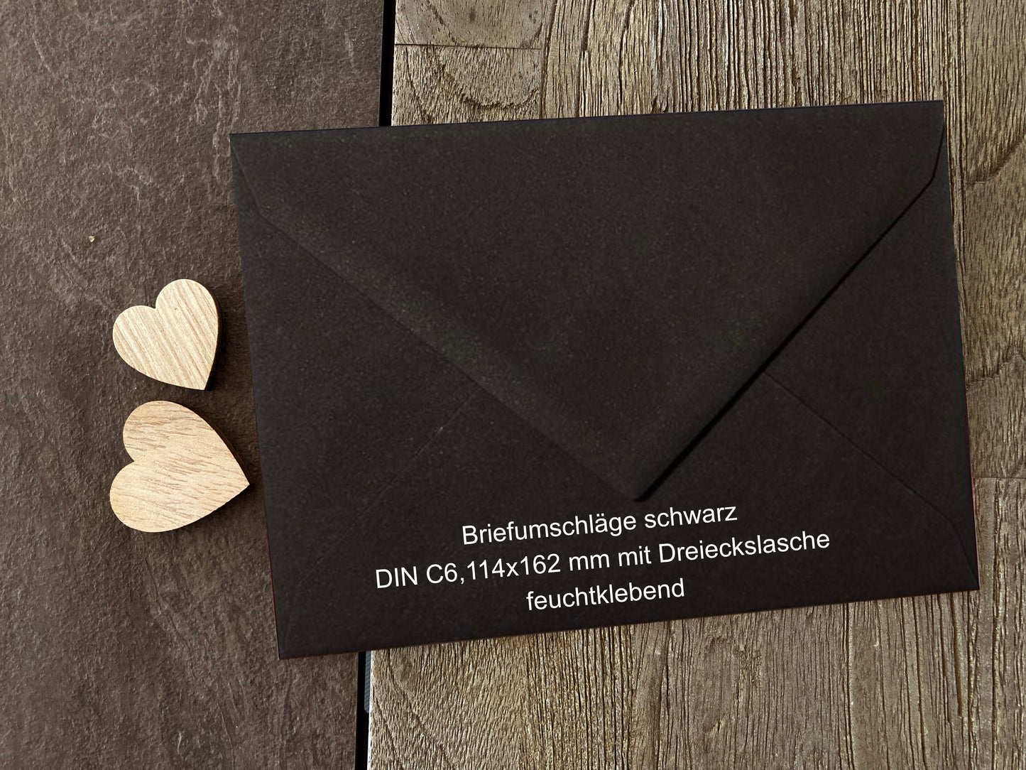 a black envelope with a wooden heart on it